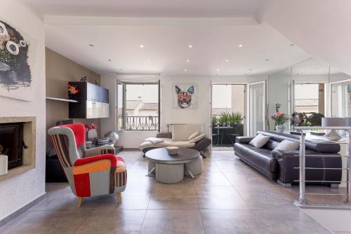 a living room with a couch and a table at Les Villas De Mandelieu by Halldis in Mandelieu-la-Napoule