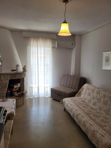 a living room with a couch and a fireplace at Queen's apartment in Olympiaki Akti