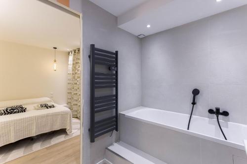 a bathroom with a bath tub in a bedroom at Les Villas De Mandelieu by Halldis in Mandelieu-la-Napoule
