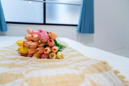 a bouquet of flowers sitting on top of a bed at 5 min walk from Gotanno station 20sqm apartment with private toilet and bathroom Direct access to popular travel destinations such as Ueno in Tokyo