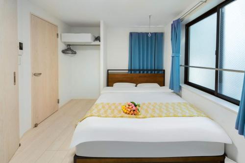 a bedroom with two beds and a bowl of fruit at 5 min walk from Gotanno station 20sqm apartment with private toilet and bathroom Direct access to popular travel destinations such as Ueno in Tokyo
