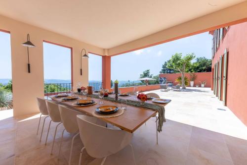 a dining room with a long table and chairs at Villa Les Chants Vallonnés in Spéracèdes