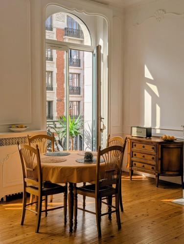 une salle à manger avec une table et des chaises et une fenêtre dans l'établissement Lille hypercentre - Charming T2 with balcony, à Lille