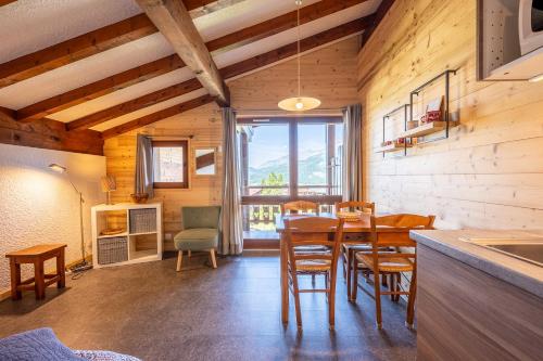 une cuisine et une salle à manger avec une table et des chaises dans l'établissement Studio 18 - Le Chamois, à Cohennoz