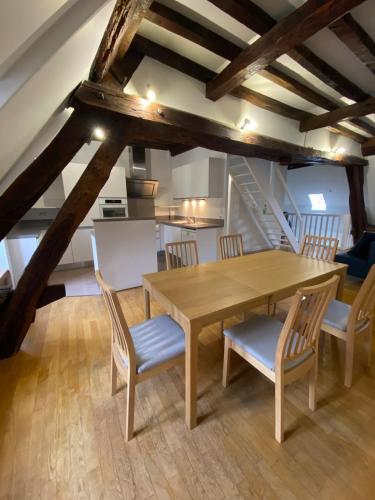 une salle à manger avec une table et des chaises en bois dans l'établissement Appartement coeur de Beaune, à Beaune