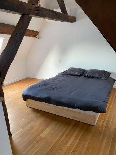 une chambre avec un lit avec une couette bleue dans l'établissement Appartement coeur de Beaune, à Beaune