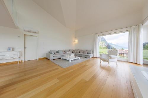 a large white living room with a large window at Villa Miraggio by MyVillaCollection in Tremezzo