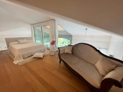 a bedroom with a bed and a couch at Villa Miraggio by MyVillaCollection in Tremezzo
