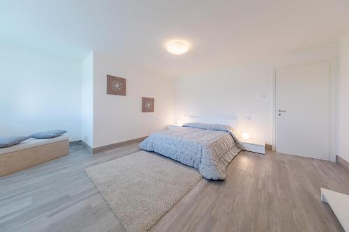 a white bedroom with a bed and a rug at Villa Miraggio by MyVillaCollection in Tremezzo