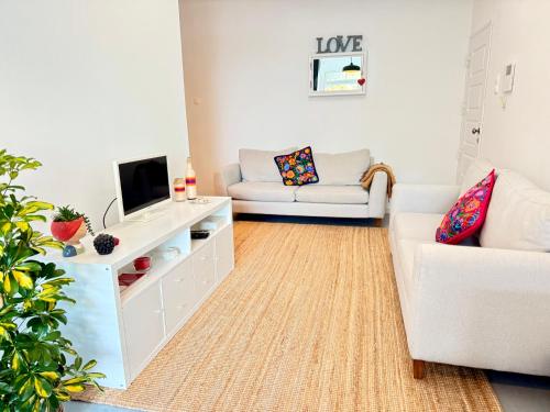 a living room with a couch and a tv at Cosy apartment Estoril in Estoril