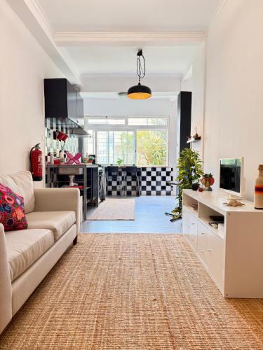 a living room with a couch and a kitchen at Cosy apartment Estoril in Estoril