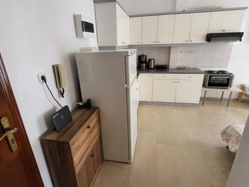 a kitchen with a white refrigerator in a room at Queen's apartment in Olympiaki Akti