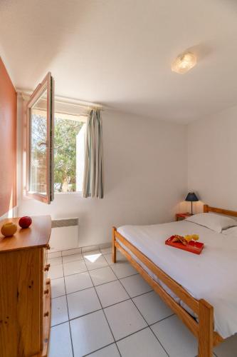 une chambre avec un lit et une fenêtre dans l'établissement Lagrange Vacances - Les Hameaux de l'Océan, à Carcans