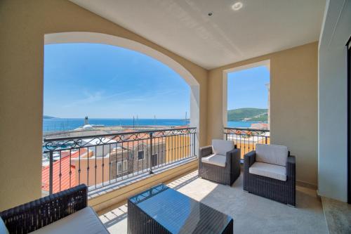 a balcony with chairs and a view of the ocean at Lustica Bay Marina Village by 2BHome in Lustica