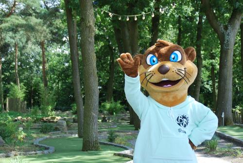 a mascot in a park with his hand in the air at Glamping BreeBronne in Maasbree