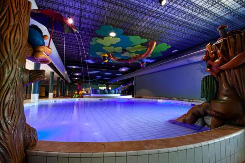 a swimming pool with blue lighting in a building at Glamping BreeBronne in Maasbree