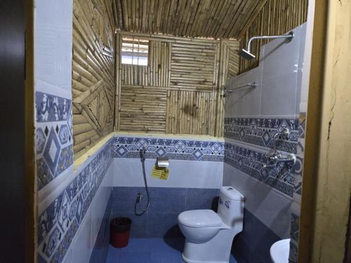 a bathroom with a toilet and a sink at Babylon Bamboo Cottage in Pokhara