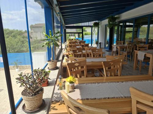a restaurant with tables and chairs and a view of the water at Valahia in Dunavăţu de Jos