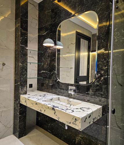 a bathroom with a sink and a mirror at The White Suites in Karachi
