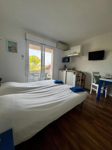 un grand lit blanc dans une chambre avec une fenêtre dans l'établissement Cosy studio ensoleillé à Saint-Florent, à Saint-Florent
