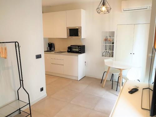 une cuisine avec des placards blancs et une petite table dans l'établissement Studio centre mer 306, à Nice