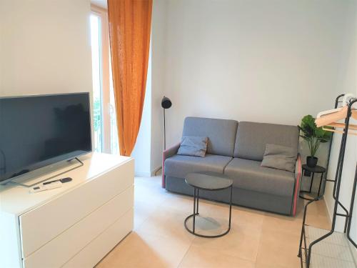 un salon avec un canapé et une télévision dans l'établissement Studio centre mer 306, à Nice