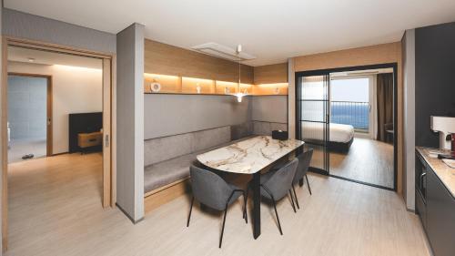 a room with a table and chairs and a bedroom at PANAQ operated by SONO in Yeongdeok