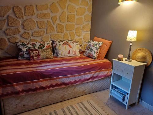 un lit dans une chambre avec un mur en pierre dans l'établissement A nice break, à Uzès
