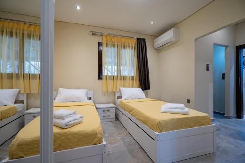 a bedroom with two beds and a mirror at Seaside Serenity Retreat - Nea Makri by ΜΡS in Nea Makri