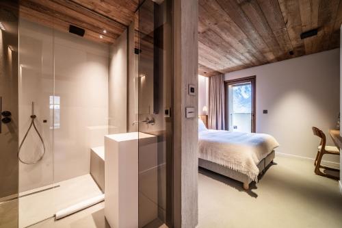 a bedroom with a bed and a glass shower at Chalet Foxden in Les Houches