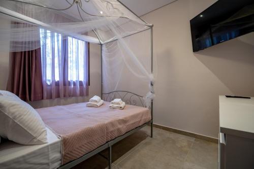 a bedroom with a canopy bed with towels on it at Seaside Serenity Retreat - Nea Makri by ΜΡS in Nea Makri