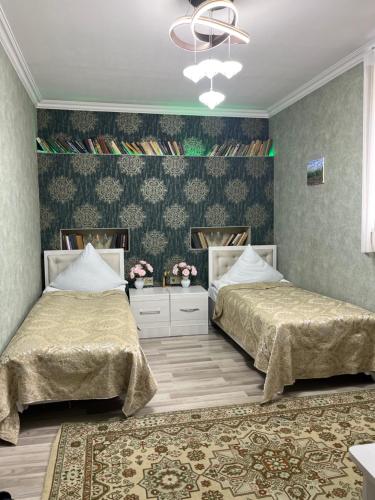 a bedroom with two beds and a mirror at Mehriban Guest House in Sheki