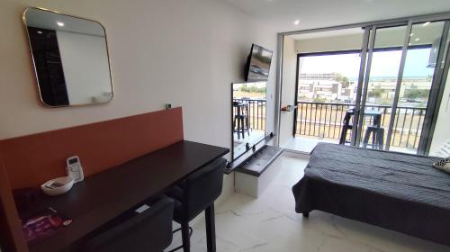 - une chambre avec un bureau, un lit et un balcon dans l'établissement Studio Naturiste Vue Mer New, au Cap d'Agde