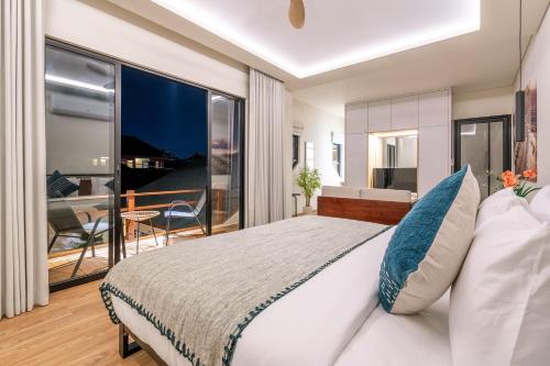 a bedroom with a large bed and a balcony at Oasis Residences in Sanur