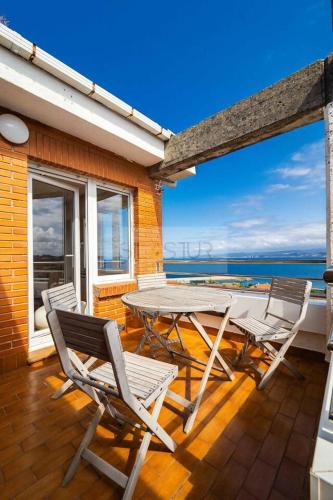 a patio with a table and chairs on a balcony at Antoxana By Silastur in Luanco