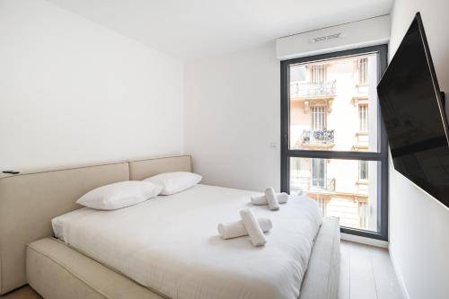 une chambre blanche avec un lit et une fenêtre dans l'établissement Appartement de Charme II 2BR Beausoleil Monaco, à Beausoleil