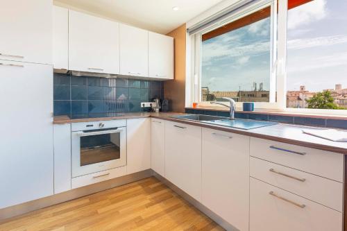 une cuisine avec des armoires blanches et une fenêtre dans l'établissement Vauban City-center 1 bedroom apartment in Antibes with AC, à Antibes
