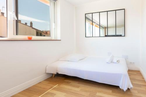 une chambre blanche avec un lit et une fenêtre dans l'établissement Vauban City-center 1 bedroom apartment in Antibes with AC, à Antibes