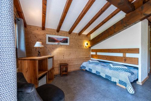 une chambre avec un lit et un bureau dans une pièce dans l'établissement Studio 16 - Le Lagopede, à Cohennoz