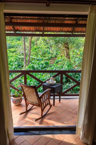 a patio with a table and a chair on a porch at Old Kent Estates & Spa, Coorg in Suntikoppa