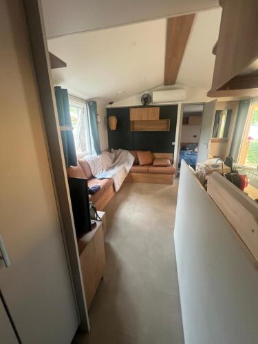 Cette petite chambre comprend un lit et un canapé. dans l'établissement Mobil Home C06 camping Siblu La Plage MIMIZAN, à Mimizan-Plage