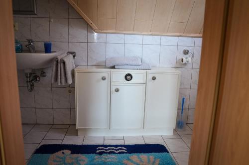 a bathroom with a white cabinet and a sink at Pension Eger in Treuchtlingen