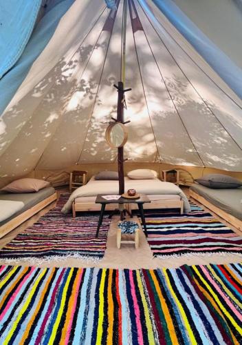 - une chambre avec 2 lits et un tapis dans une tente dans l'établissement Kârma Hôtel, à Saint-Germain-Laval