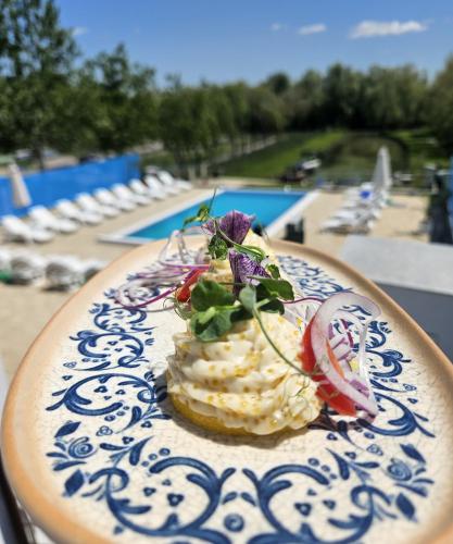 a dessert on a blue and white plate next to a pool at Valahia in Dunavăţu de Jos