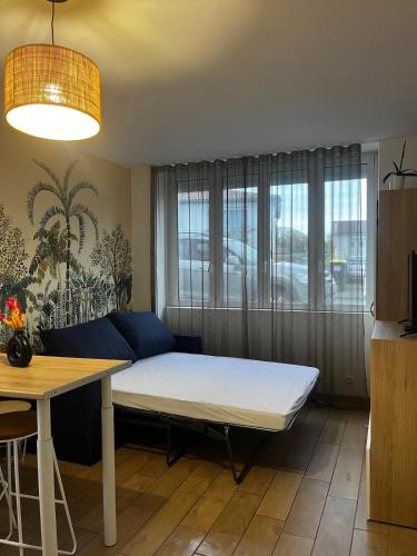 un salon avec un lit et une table dans l'établissement Studio porte royale, à La Rochelle