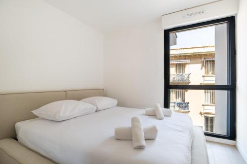 une chambre avec un lit blanc et une fenêtre dans l'établissement Charming Apartment III 2BR Beausoleil Monaco, à Beausoleil