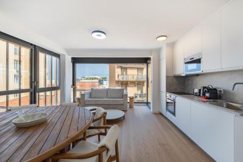 - une cuisine et une salle à manger avec une table en bois dans l'établissement Charming Apartment III 2BR Beausoleil Monaco, à Beausoleil