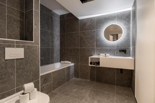 une salle de bain avec un lavabo, des toilettes et un miroir dans l'établissement Charming Apartment III 2BR Beausoleil Monaco, à Beausoleil