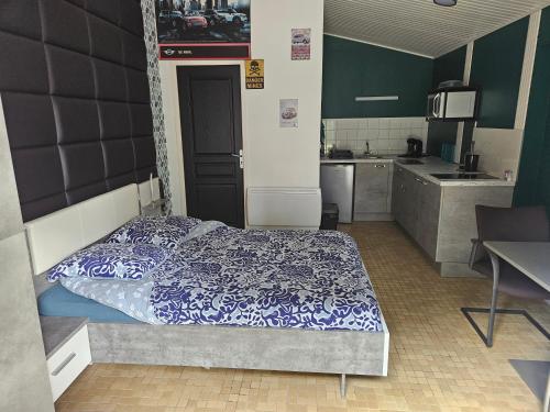 une chambre avec un lit avec une couette bleue et blanche dans l'établissement Laurier ET Menthe, à Challans