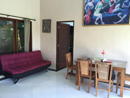 a living room with a red couch and a table at Ratna Villa in Ubud
